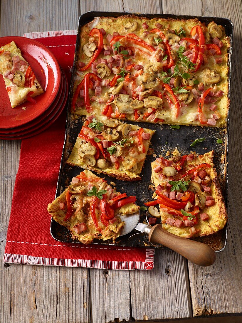 Kartoffelpizza mit Paprikaschoten, Schinken und Champignons