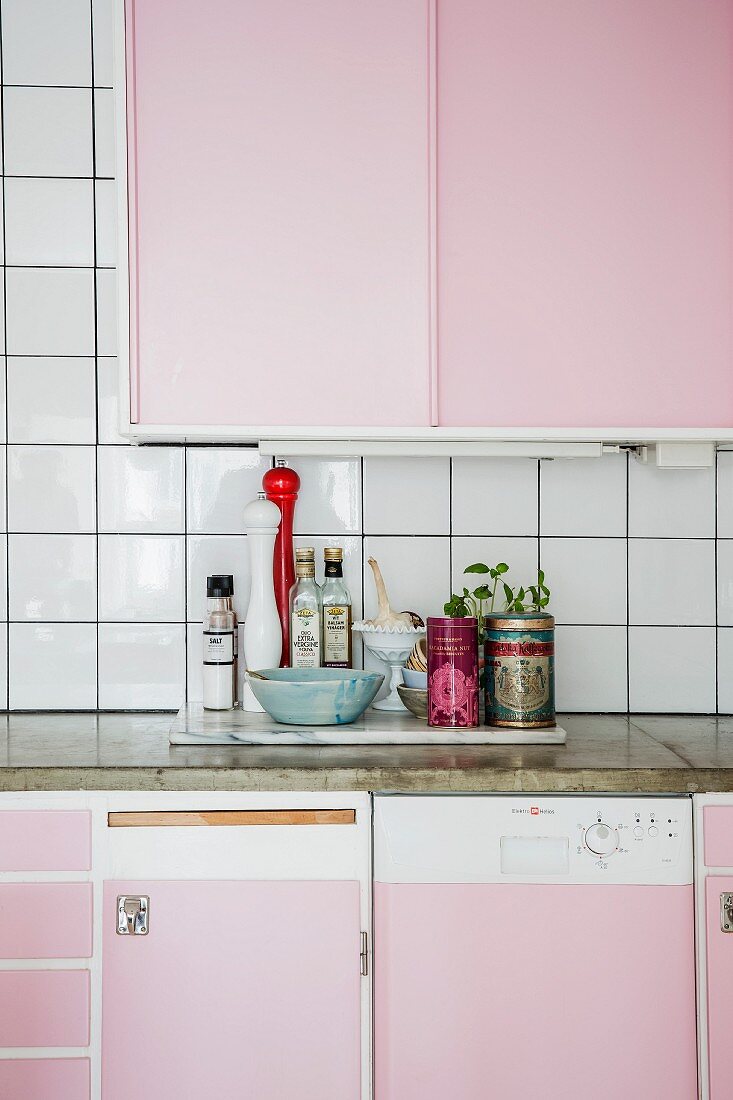 Küchenzeile mit rosa Schrankfronten und Arbeitsplatte aus Beton