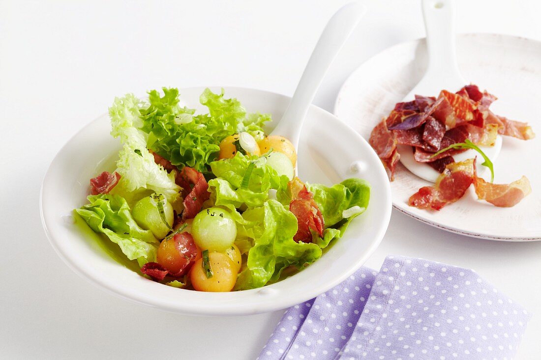 Blattsalat mit Melone und knusprig gebratenem Serranoschinken