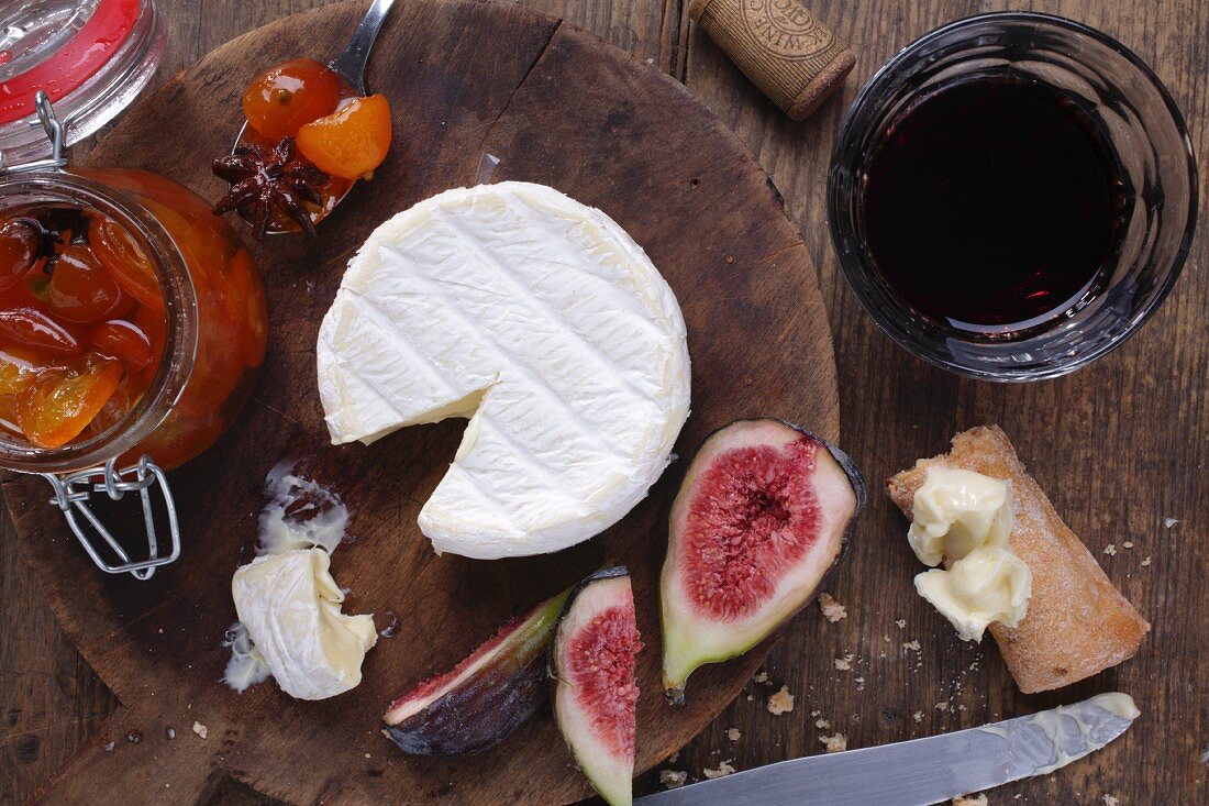 Camembert, chutney and figs on a wooden board (seen from above)