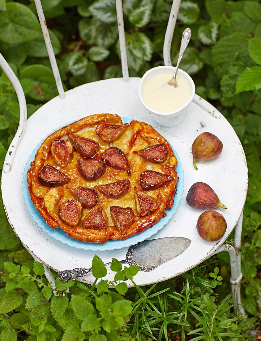 Fig tarte tatin with vanilla sauce on a garden chair