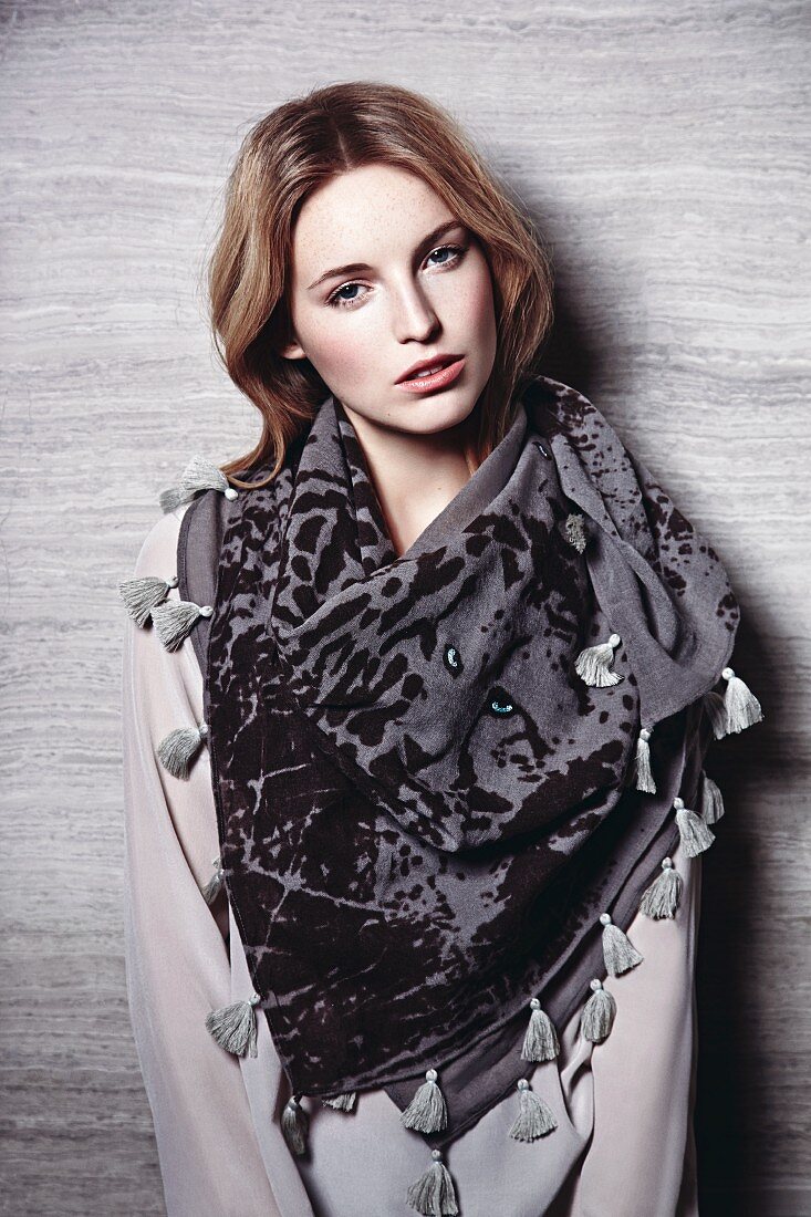 A young woman wearing a transparent shirt and leopard patterned scarf