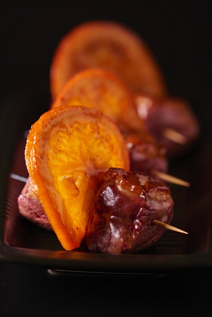 Meet skewers with bacon and candied orange slices