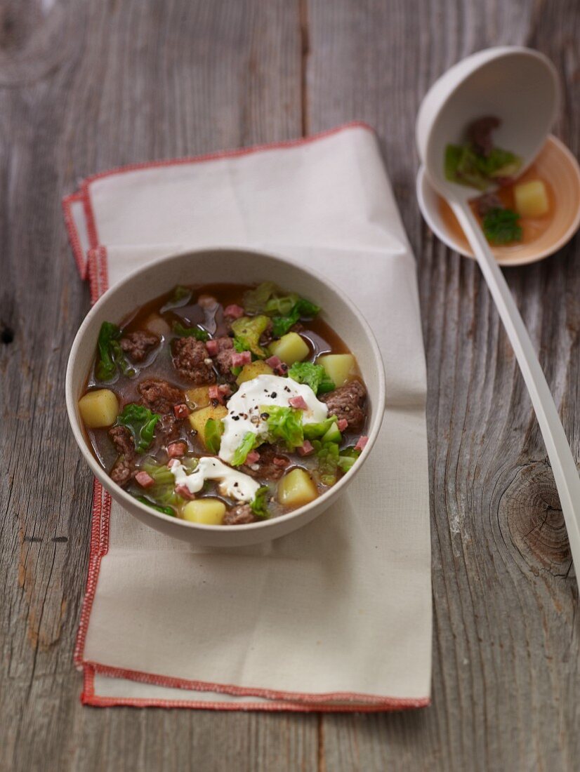 Savoy cabbage stew with minced meat, potatoes and diced bacon