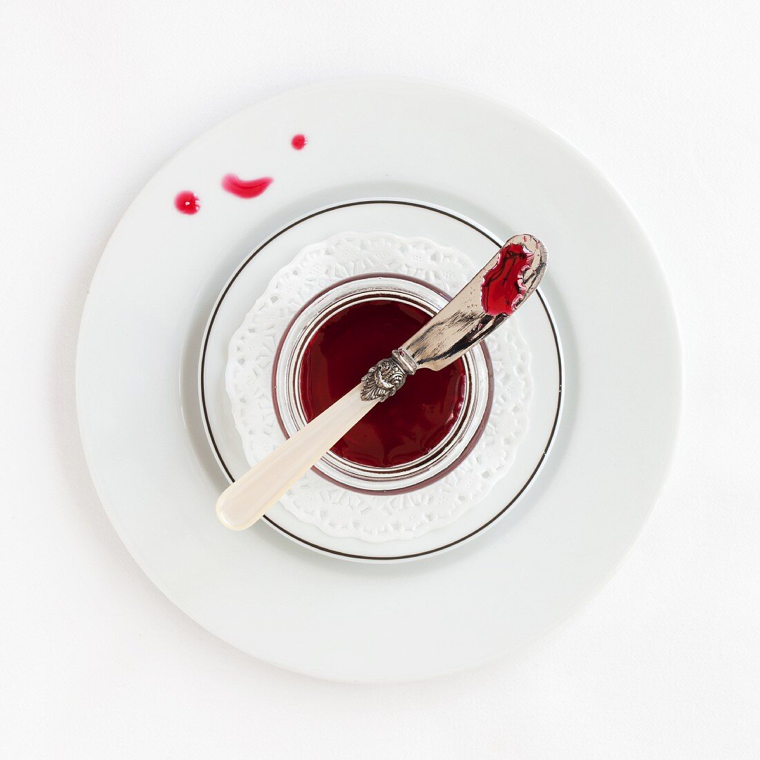 A dish of hibiscus syrup with a knife