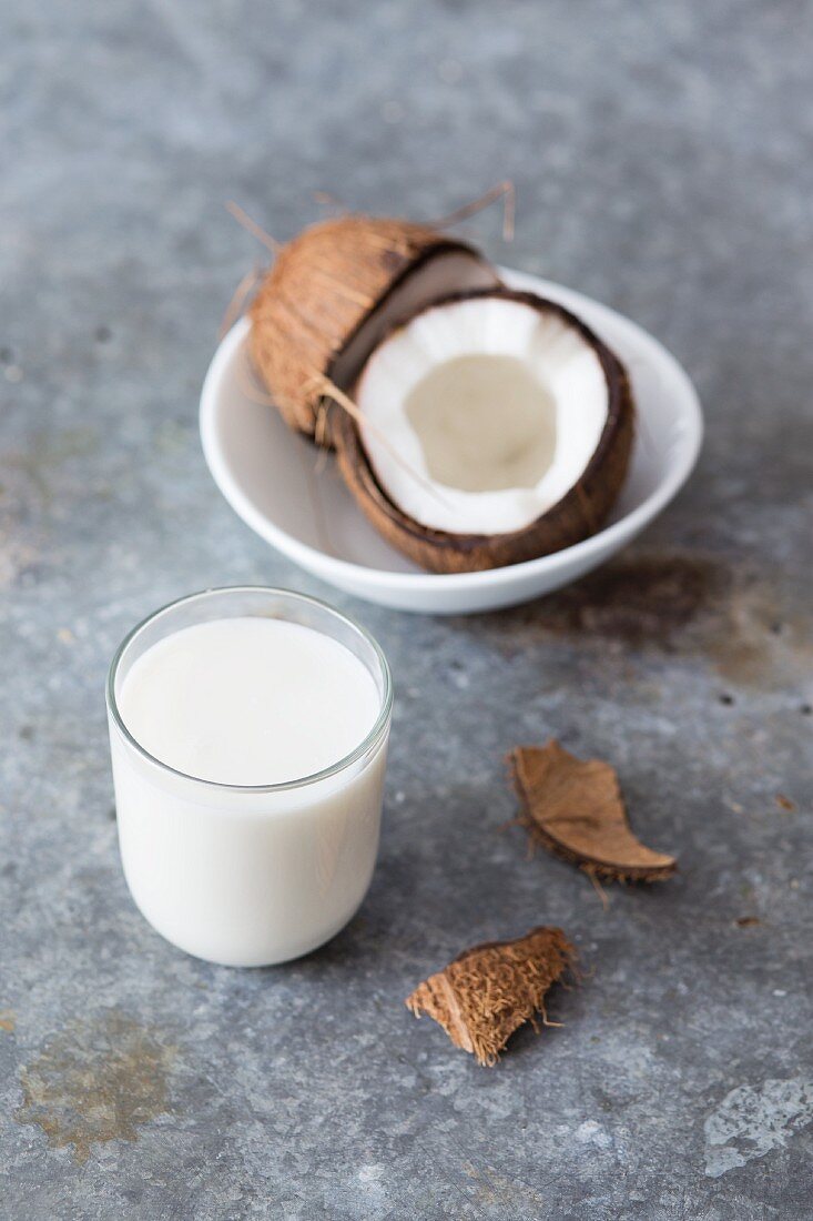 Kokosnussmilch im Glas und frische Kokosnuss