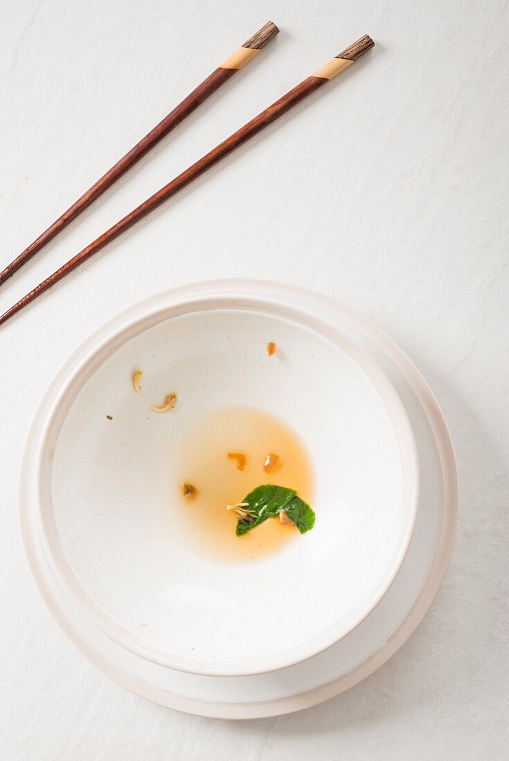 An oriental arrangement featuring an empty soup bowl and chopsticks