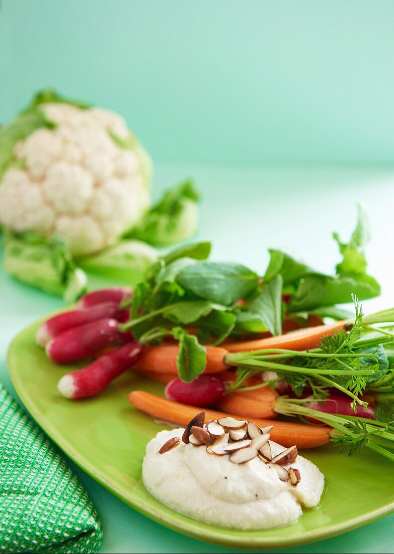 A cauliflower dip with roasted almonds and raw vegetables