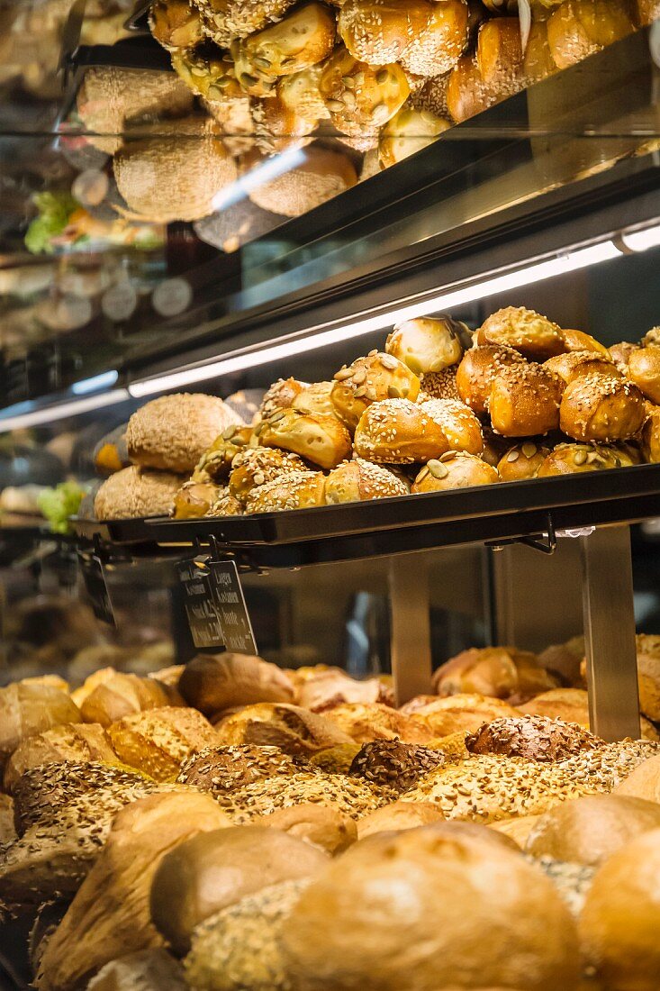 Various types of bread on shelves in a sales cabinet in the bakery