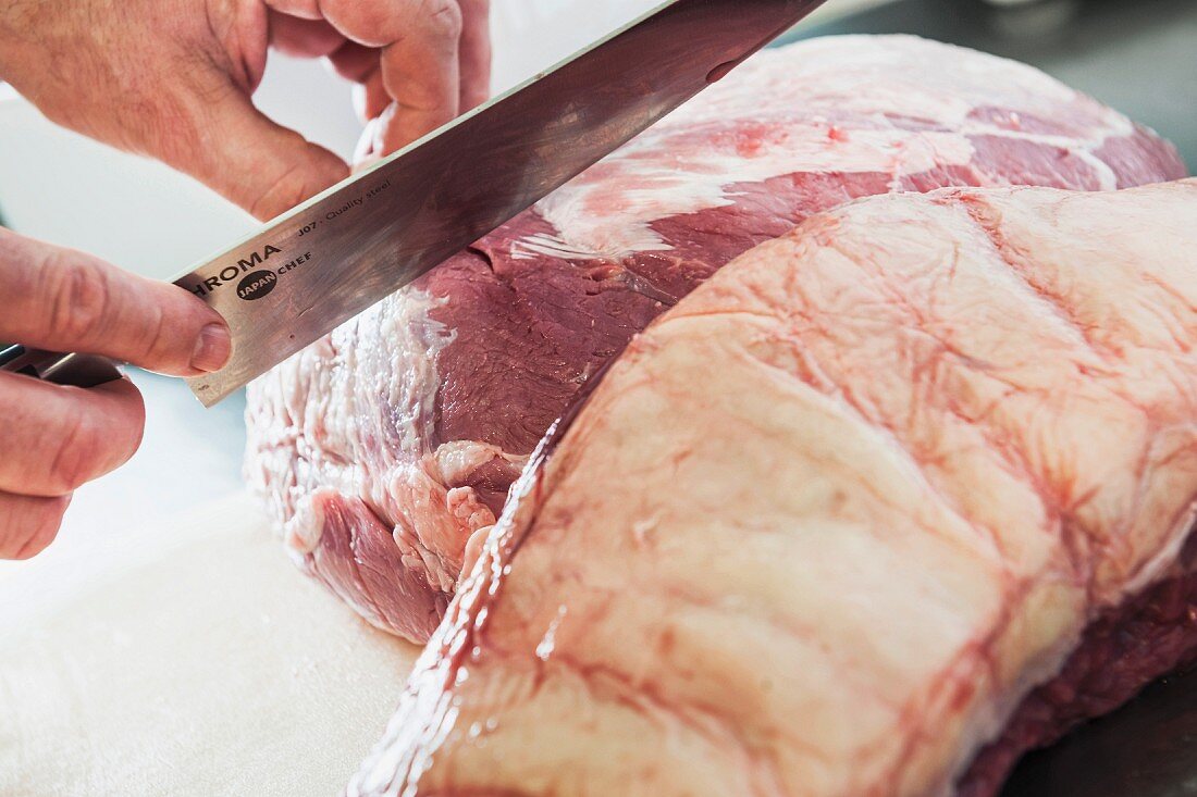 Fresh meat being carved – tendons, fat and membranes being removed