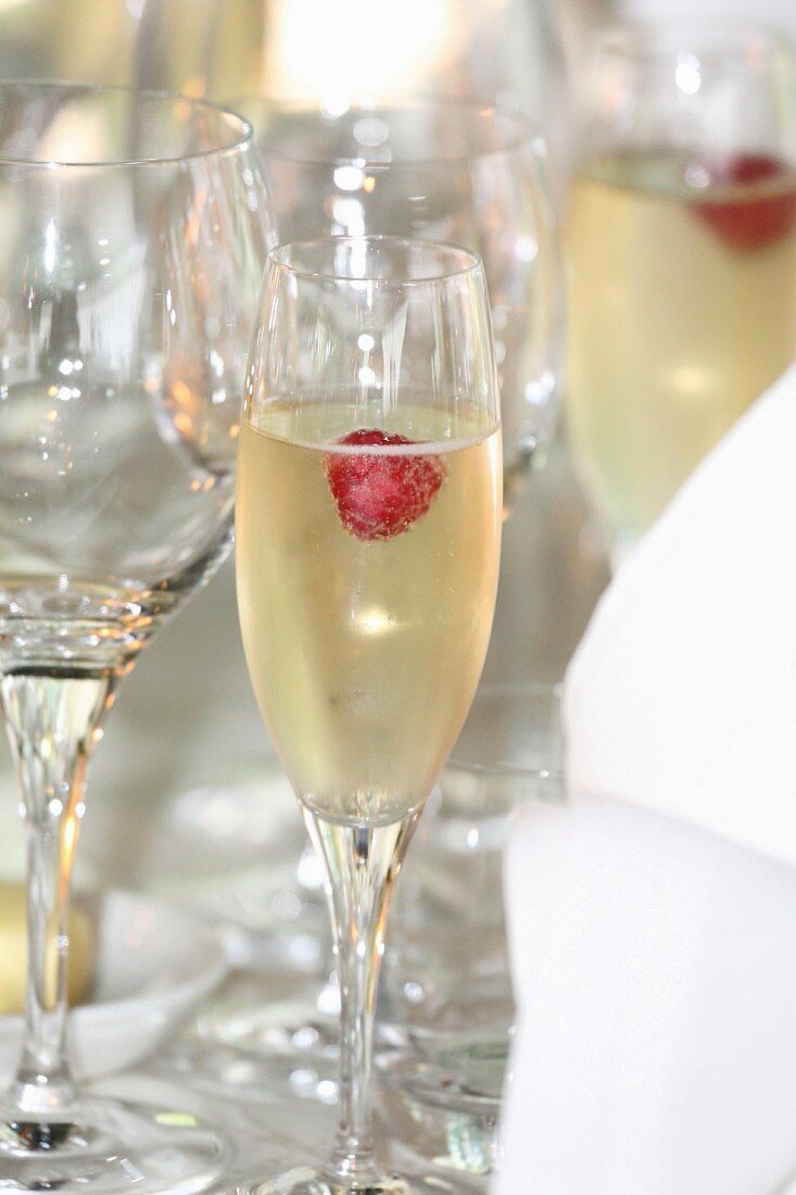 Raspberries in glasses of champagne on a table at a wedding