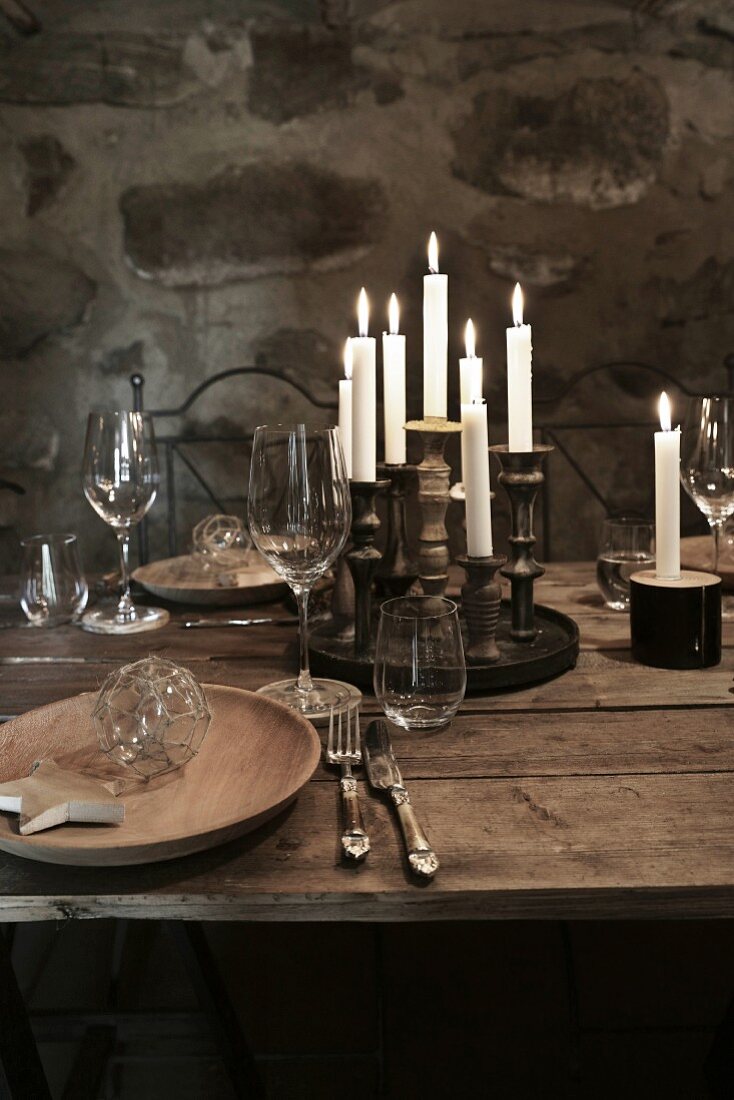 Christmas in a wine cellar: a place setting on a rustic wooden table with wine and candles