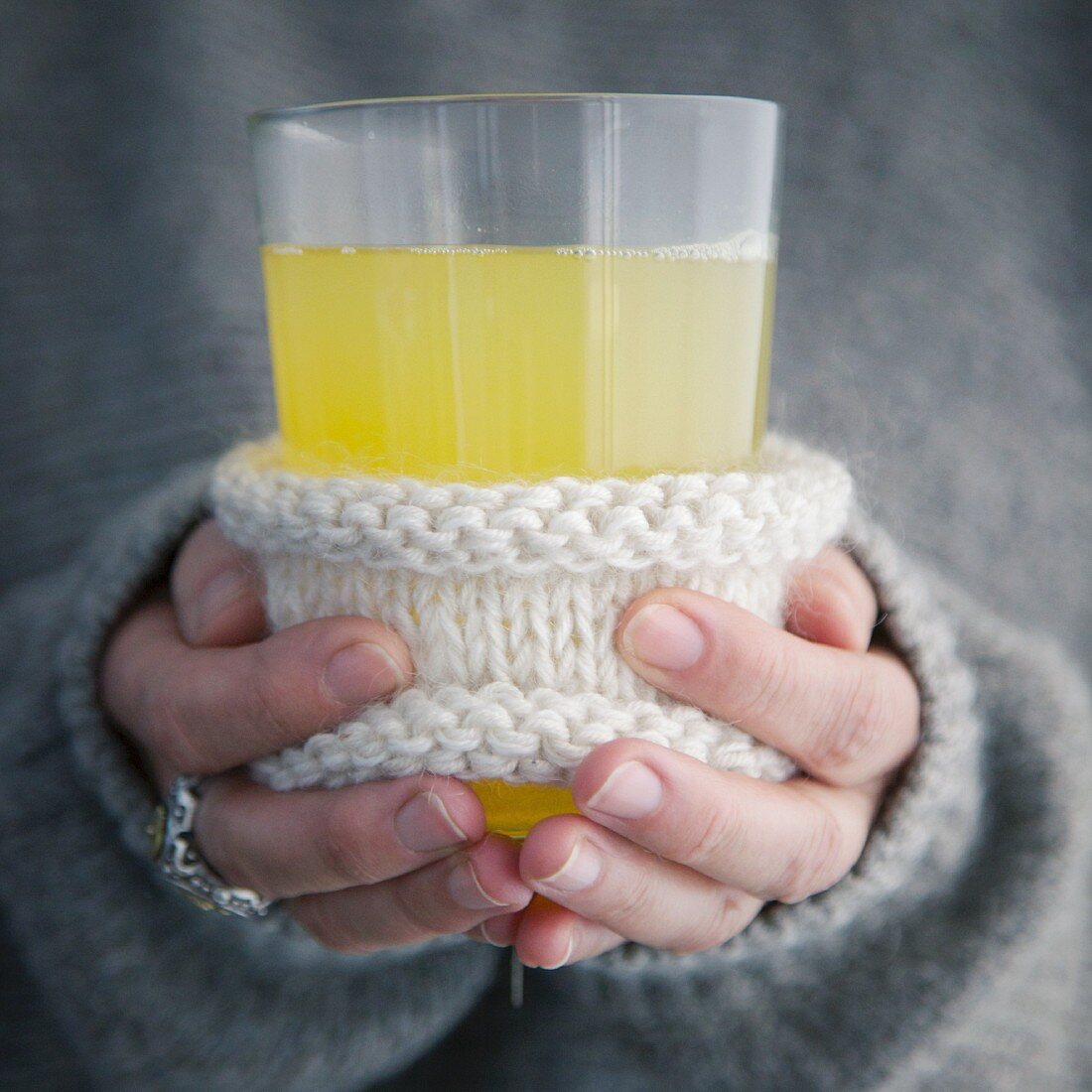 Hands holding a glass of alcohol-free elderflower punch