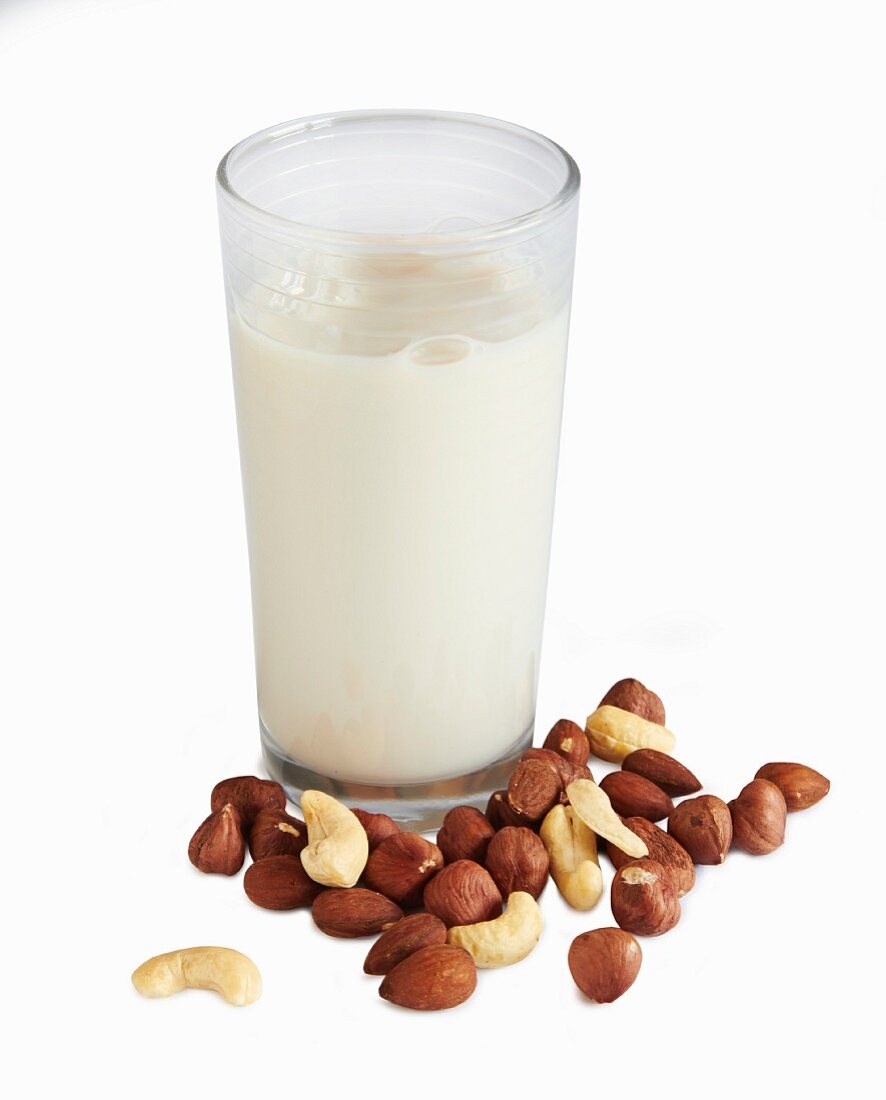 Glass of nut milk and various nuts