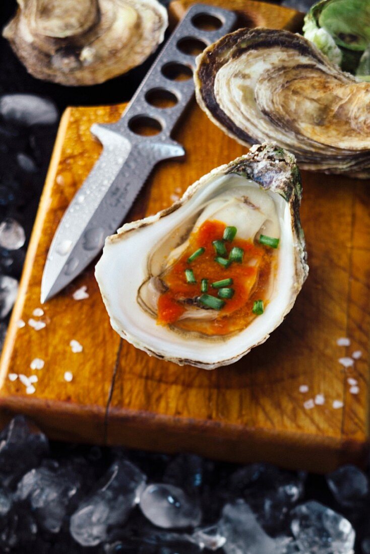 Fresh oysters with red sauce and chives