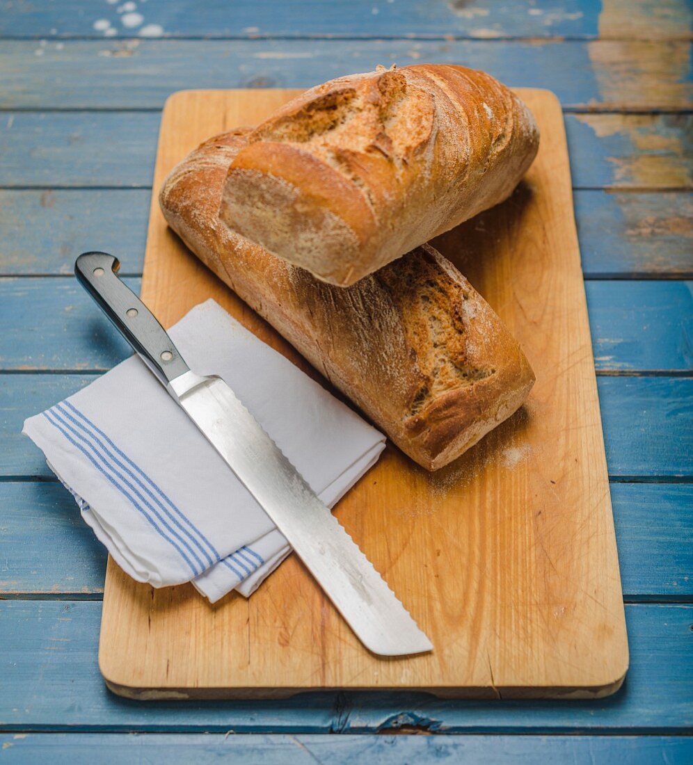 Sour dough bread on a chopping board with a knife