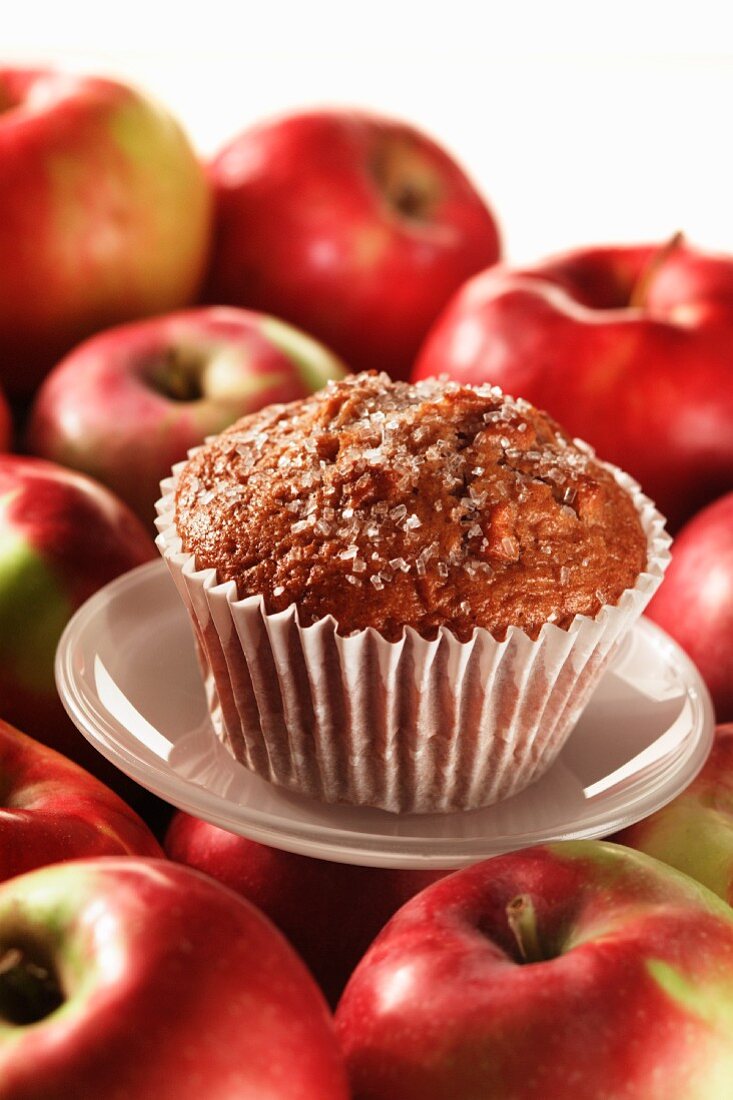 An apple muffin with red apples