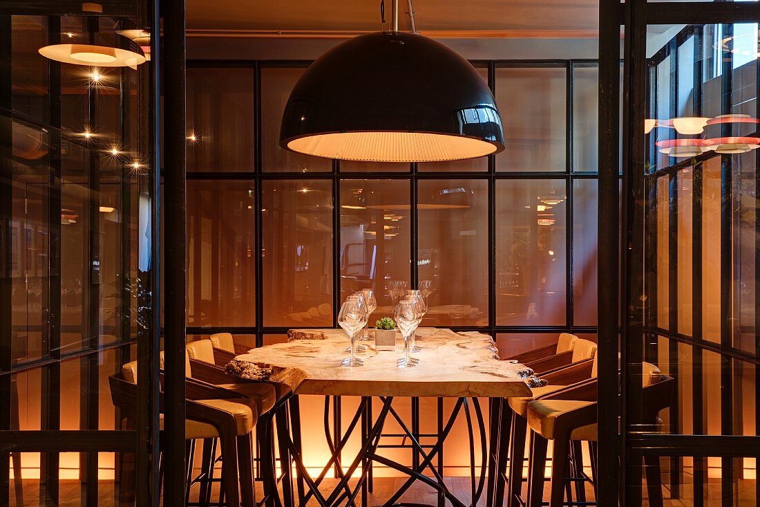 Illuminated dining table and chairs in glazed booth