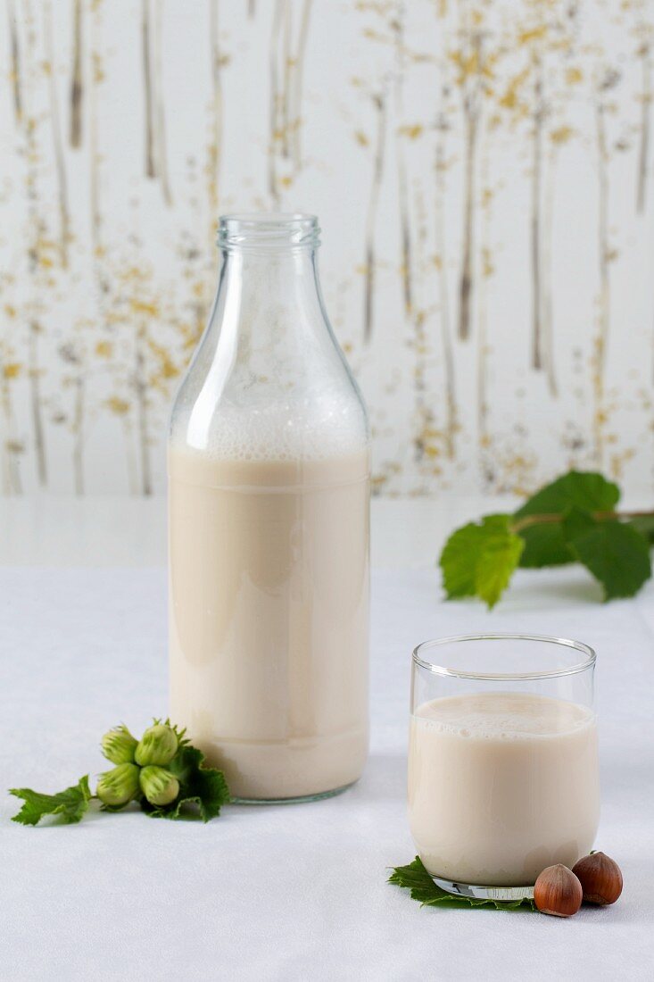 Haselnussdrink in Glas und Flasche