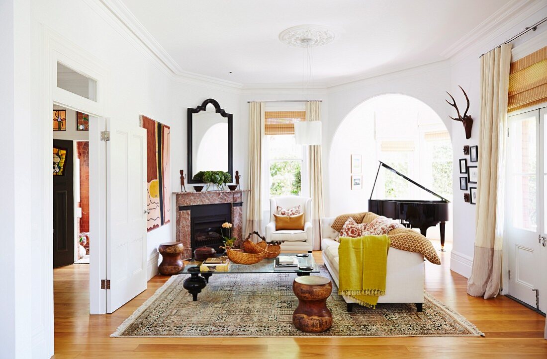 Cozy living room with an open fireplace and a grand piano