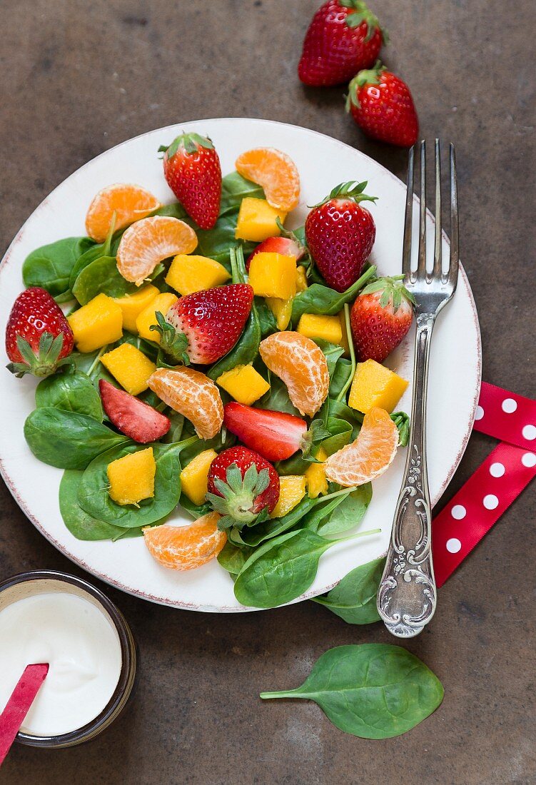 Spinach salad with fresh fruits (seen from above)