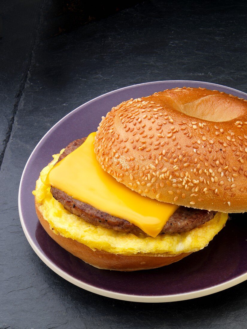 A sesame seed bagel with sausage, egg and cheese for breakfast (USA)