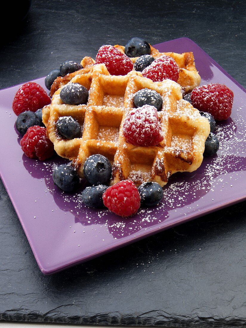 Waffles with fresh berries and icing sugar