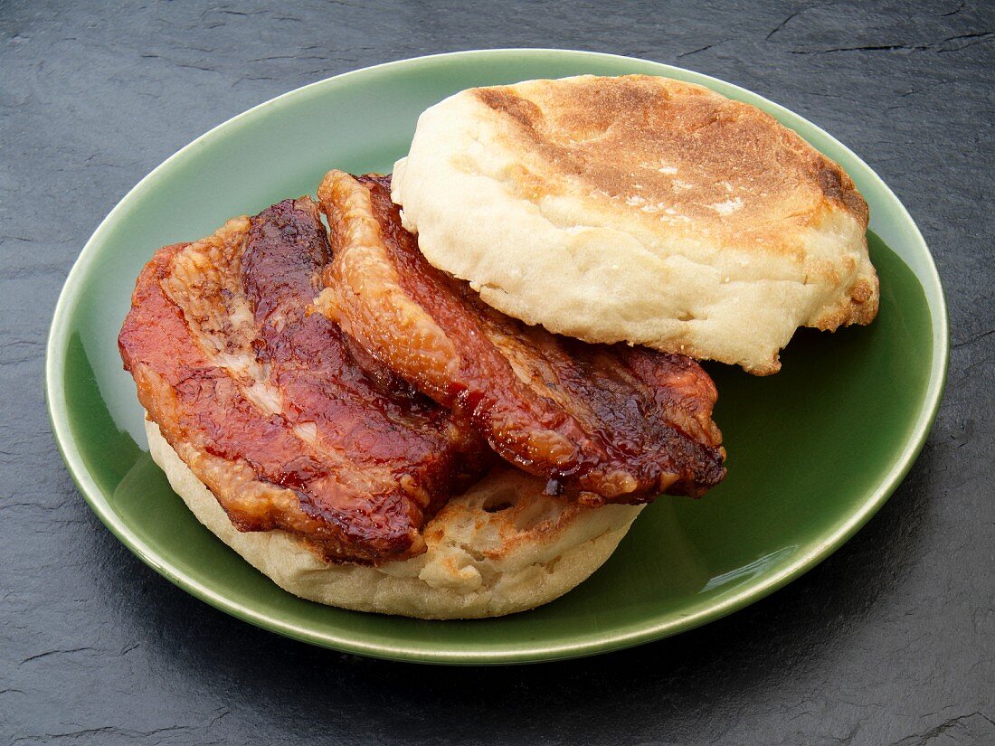 An English muffin with fried pork belly