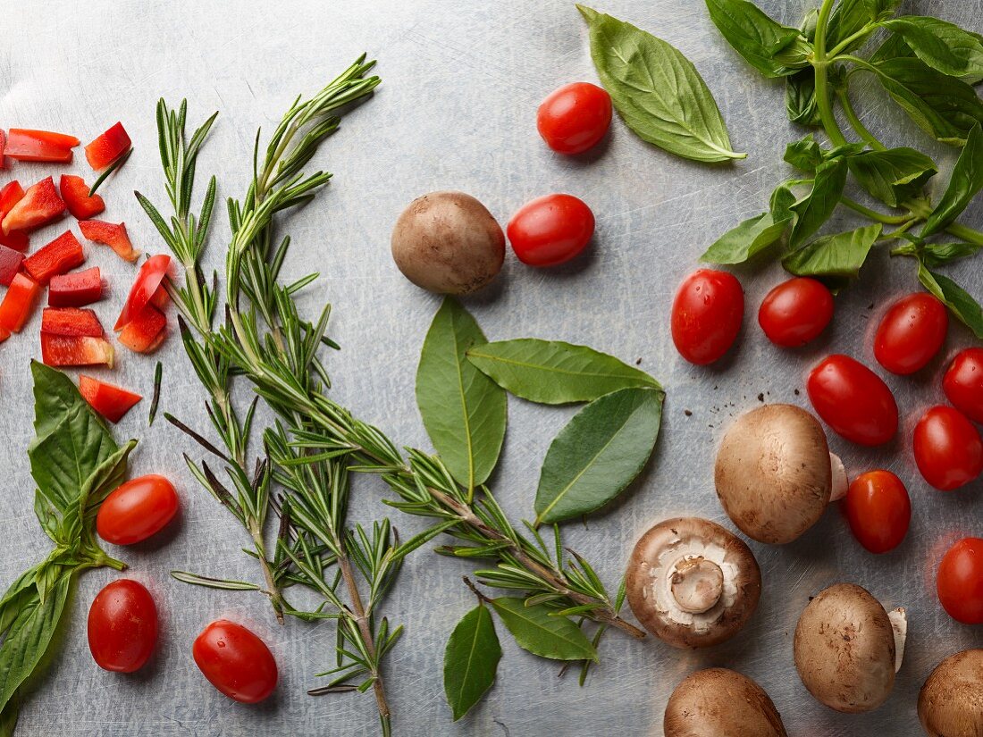 Lorbeerblätter, Rosmarin, Basilikum, Kirschtomaten, Paprika und braune Champignons