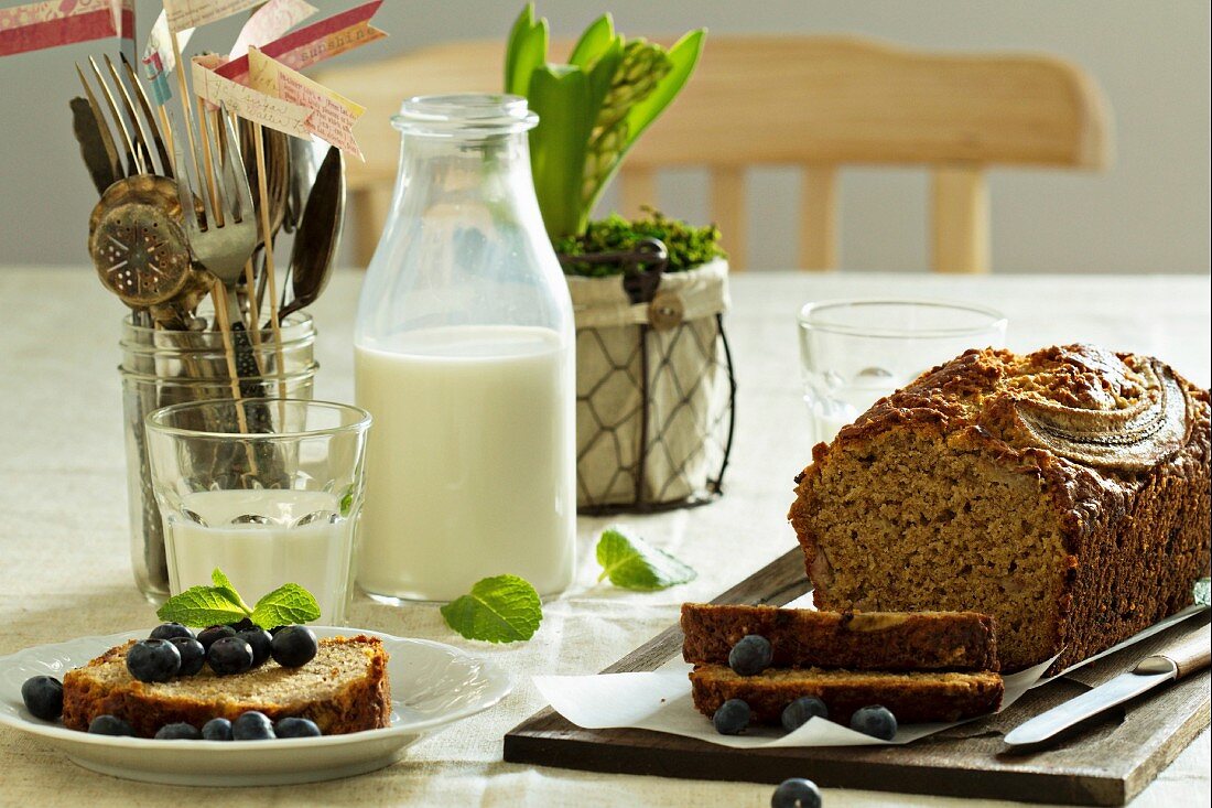 Banana bread, sliced, with blueberries and milk