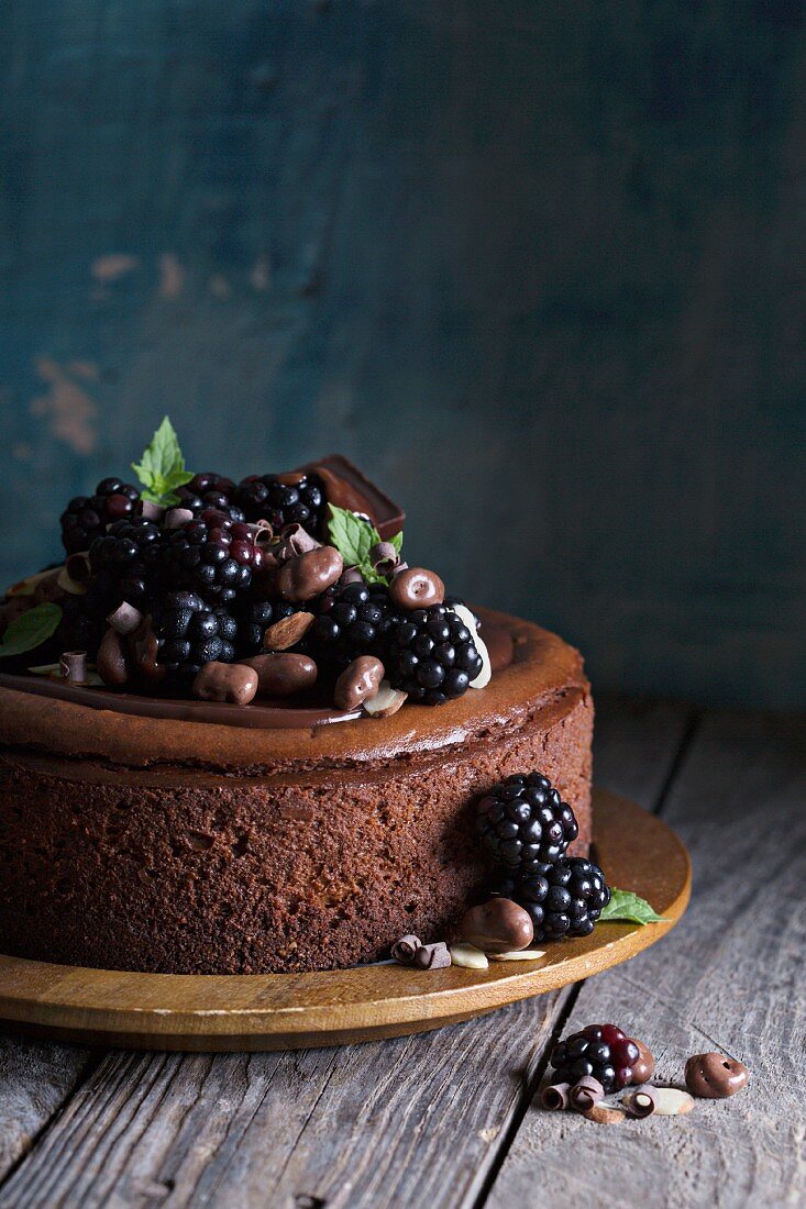 Schokoladen-Käsekuchen mit Brombeeren auf rustikalem Holzuntergrund