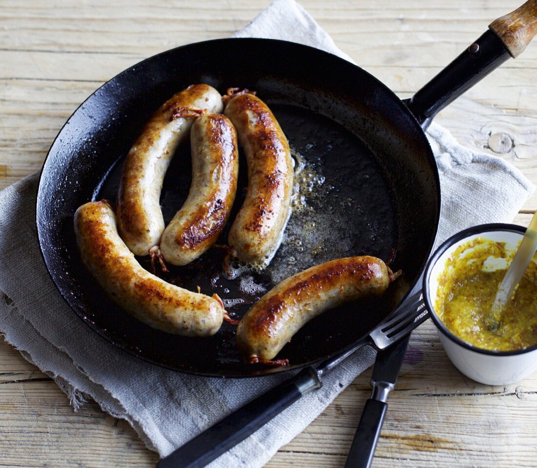 Hausgemachte grobe Bratwürste in der Pfanne braten