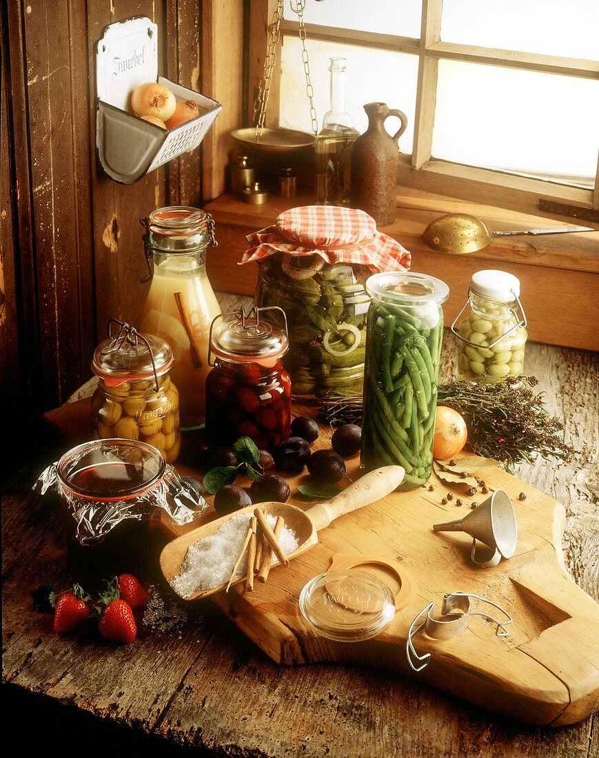 Various fruits & vegetables in preserving jars on wooden table