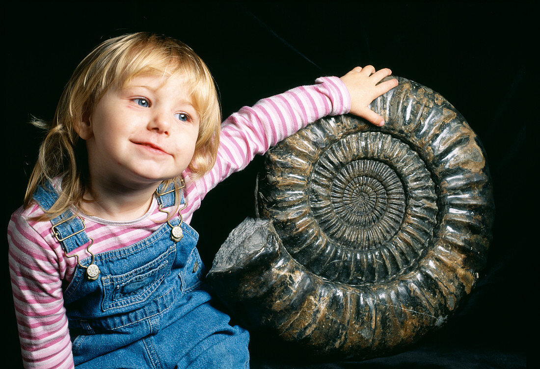 Girl with large ammonite fossil
