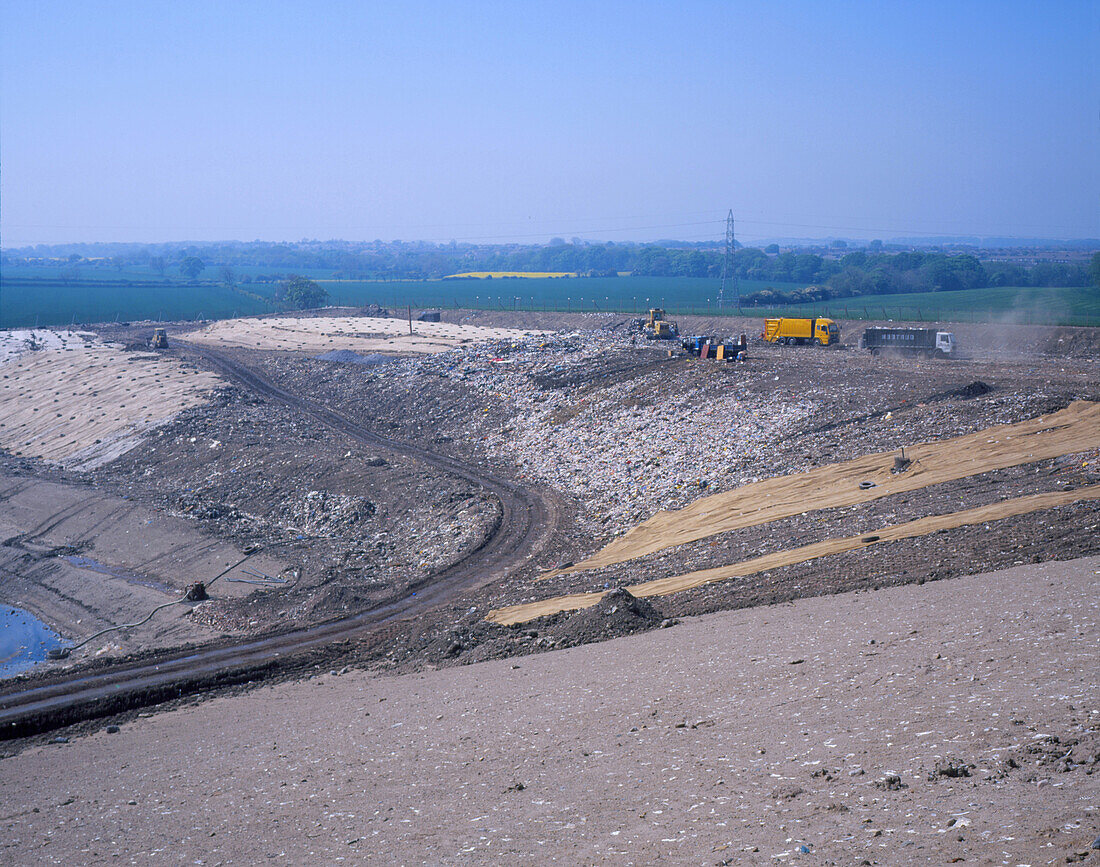 Landfill site with waste trucks and bulldozers