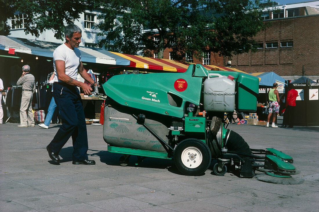 Operator cleaning a square with a large hoover