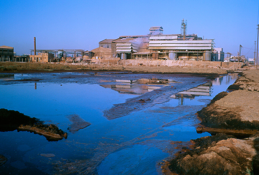 Polluted water and mud flats near a factory