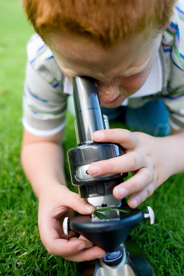 Boy using a light microscope