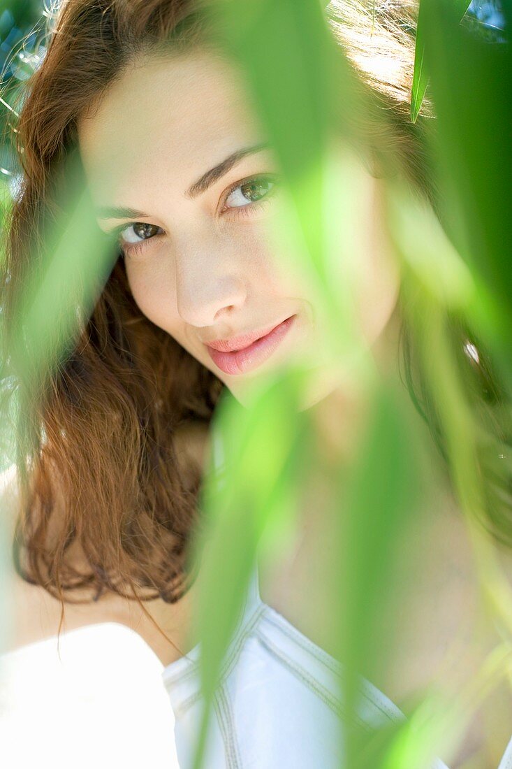 Woman looking through leaves