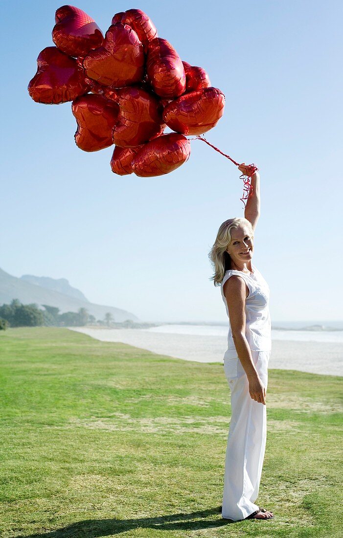 Woman holding heart-shaped balloons