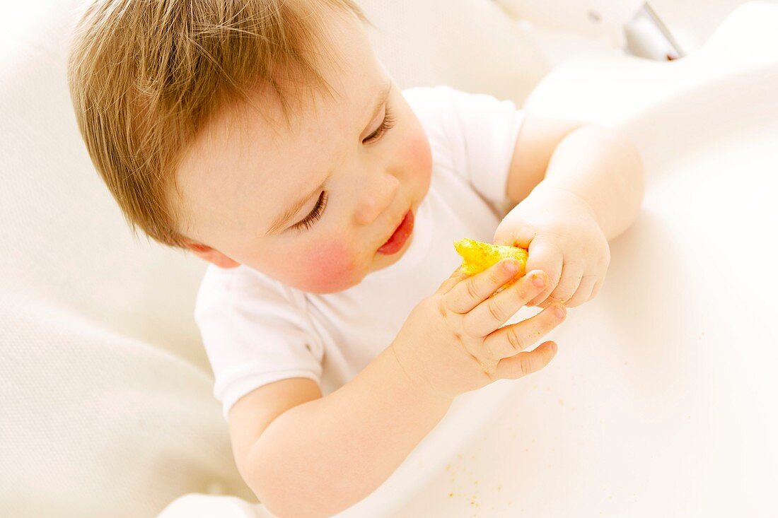 Baby boy eating a crisp