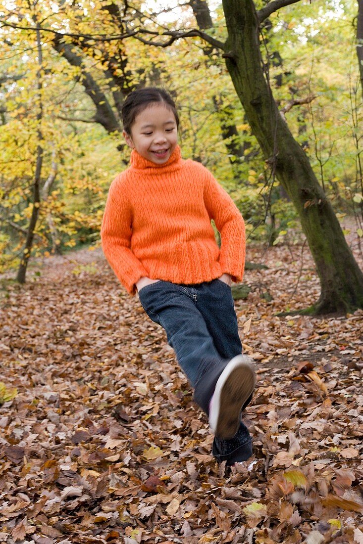 Girl kicking leaves