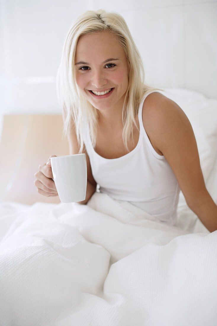 Woman drinking tea in bed