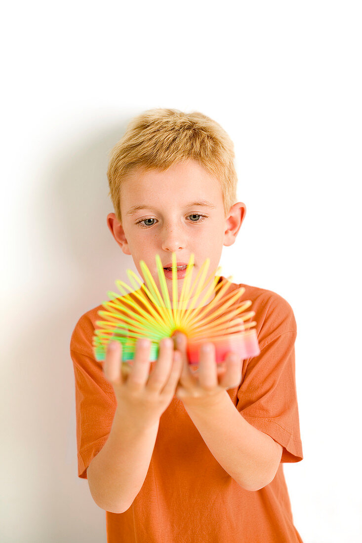 Boy playing with slinky toy