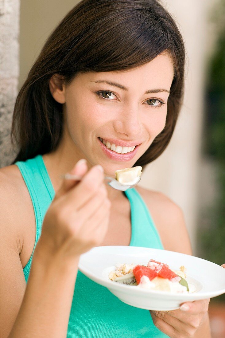Woman eating fruit salad