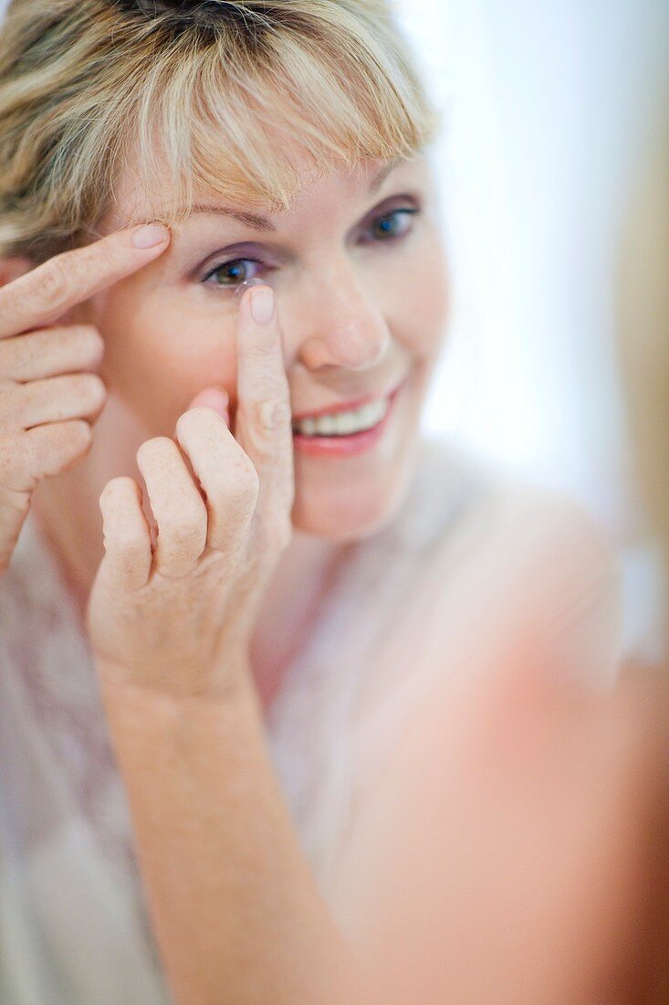 Senior woman putting in contact lenses