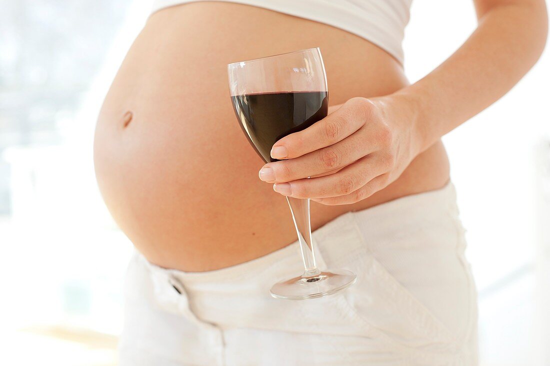 Pregnant woman with a glass of wine