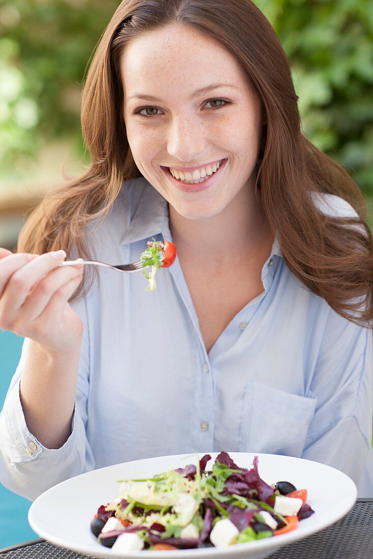 Young woman eating a salad