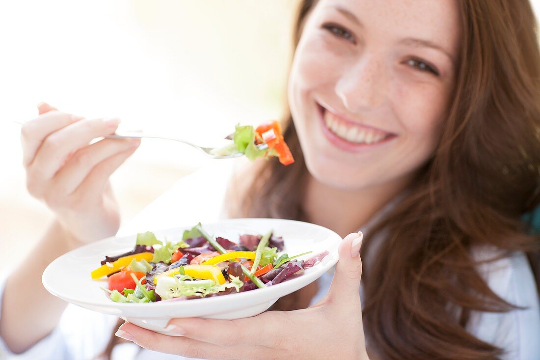 Young woman eating a salad