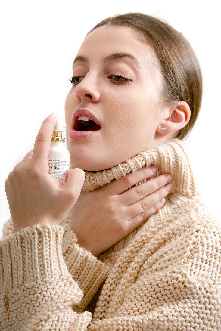 Teenage girl using throat spray